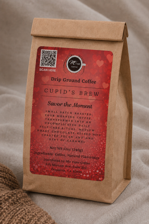 A kraft paper coffee bag standing upright on a neutral fabric surface. The bag has a large red label reading 'CUPID'S BREW' and 'Drip Ground Coffee,' with a small circular logo that appears to say 'Me Time Coffee.