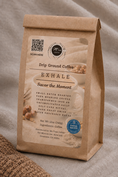 A kraft paper stand-up coffee bag labeled 'EXHALE' decaf specialty coffee by Me Time Coffee, placed on a neutral fabric surface with a textured textile prop. The bag shows product details including 'Drip Ground Coffee' and a blue 'Swiss Water' badge.