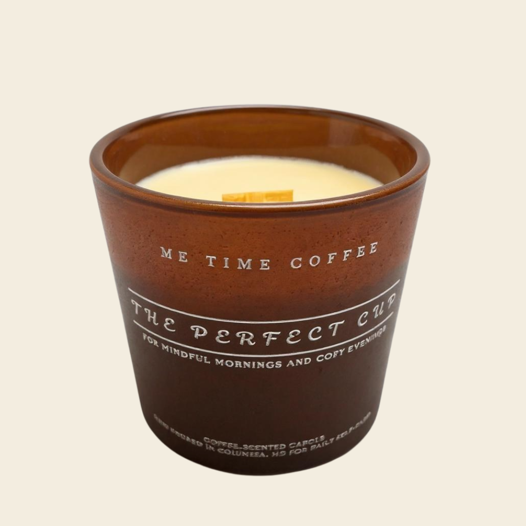 Coffee scented candle is matte Brown vessel with 'Me Time Coffee' text on a beige made with coconut apricot wax